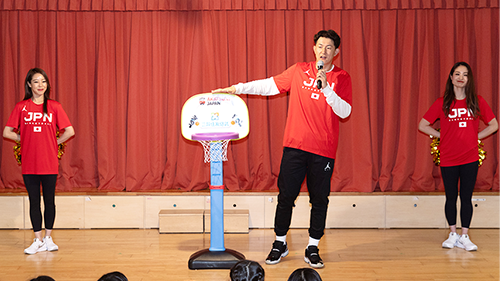 子ども向けのバスケットゴールを贈呈している様子です。