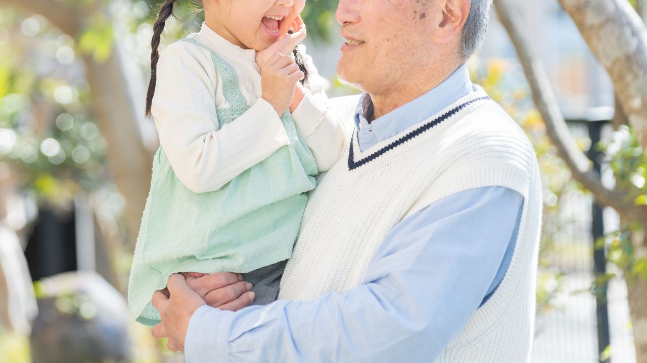 子どもを抱っこしている男性の画像