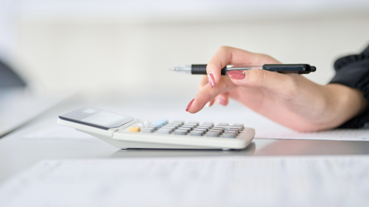 電卓で計算をする女性の画像