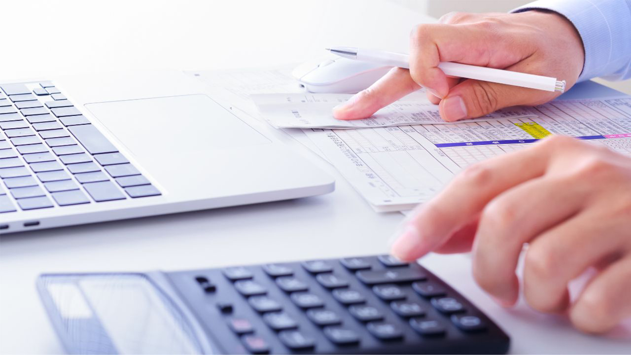 電卓を使って書類の計算をしている手元の画像