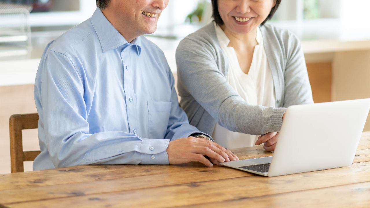 PCで企業年金の種類を調べる夫婦