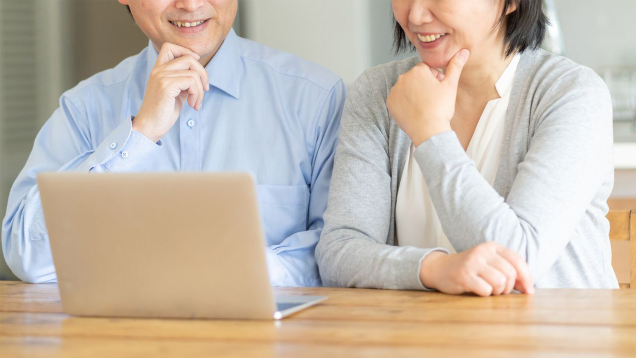 夫婦でパソコンの画面を見ている画像