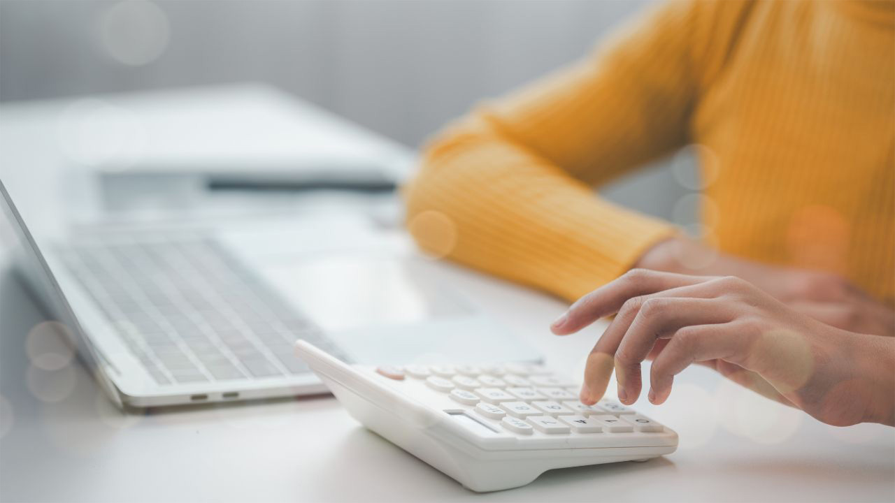 電卓をたたく女性の画像