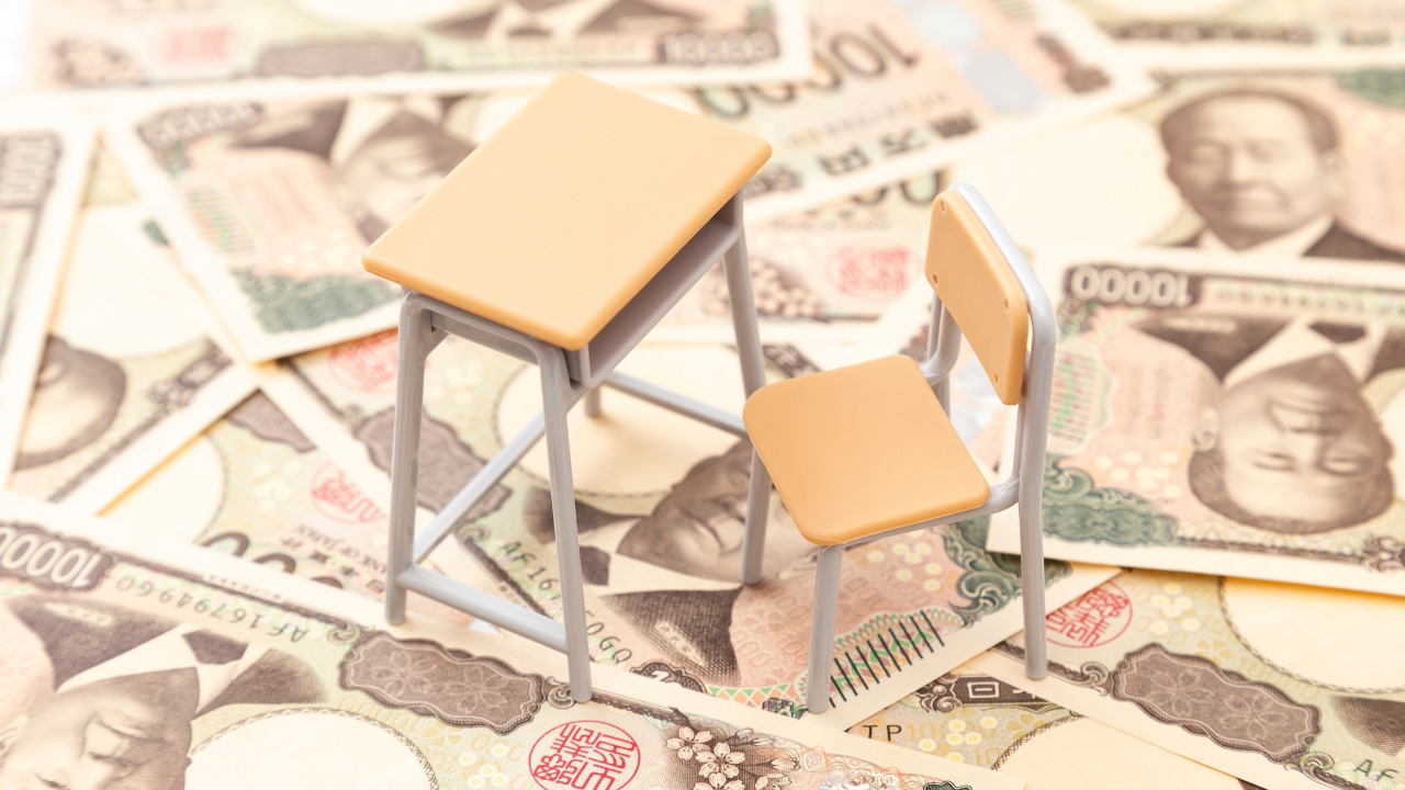 お札と小さな机と椅子の模型の画像