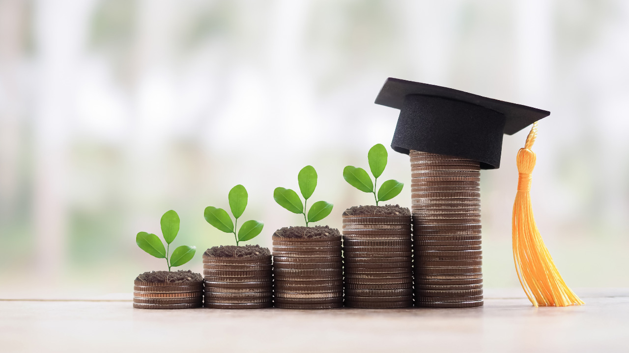 積み重ねられた硬貨と卒業帽の画像