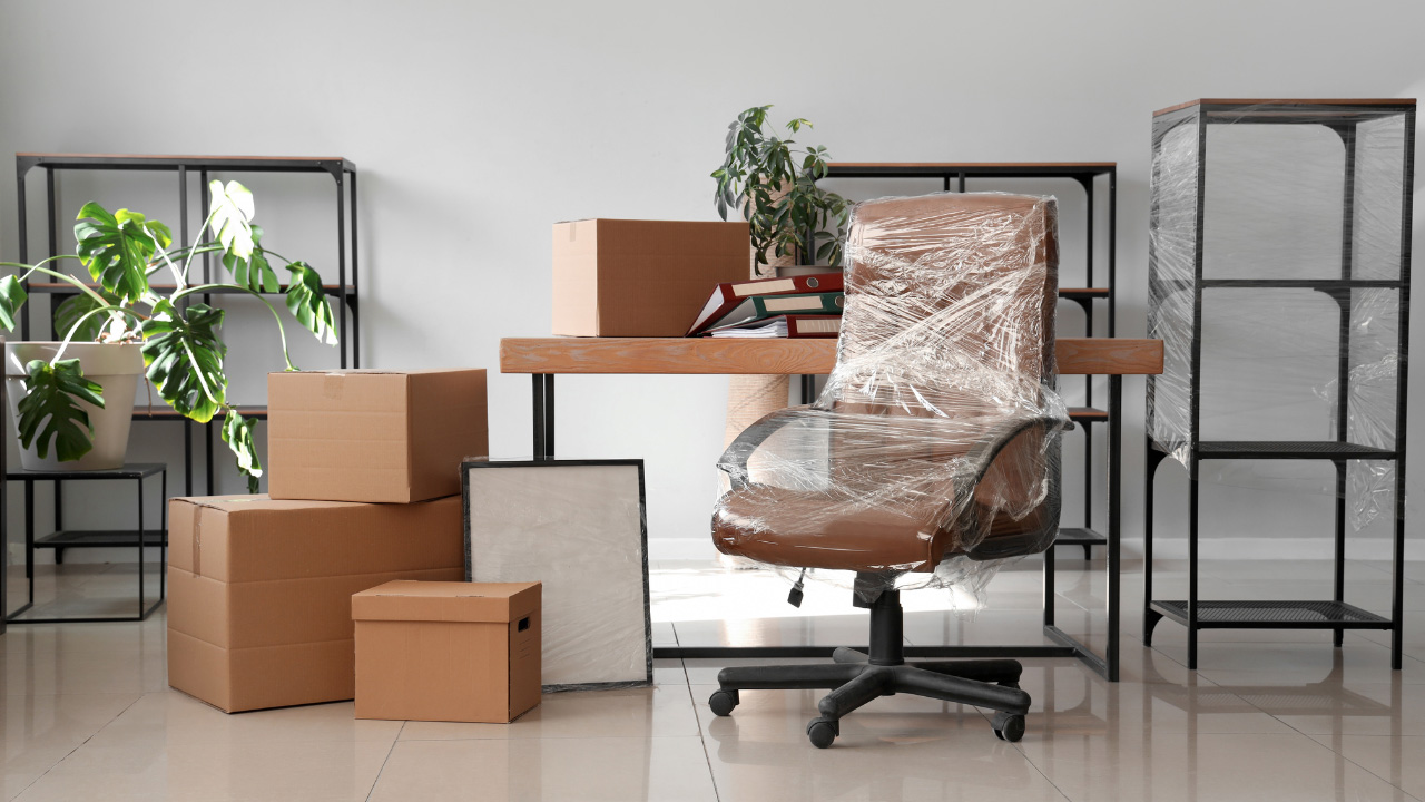 積まれた段ボール箱や梱包された椅子が置かれた画像
