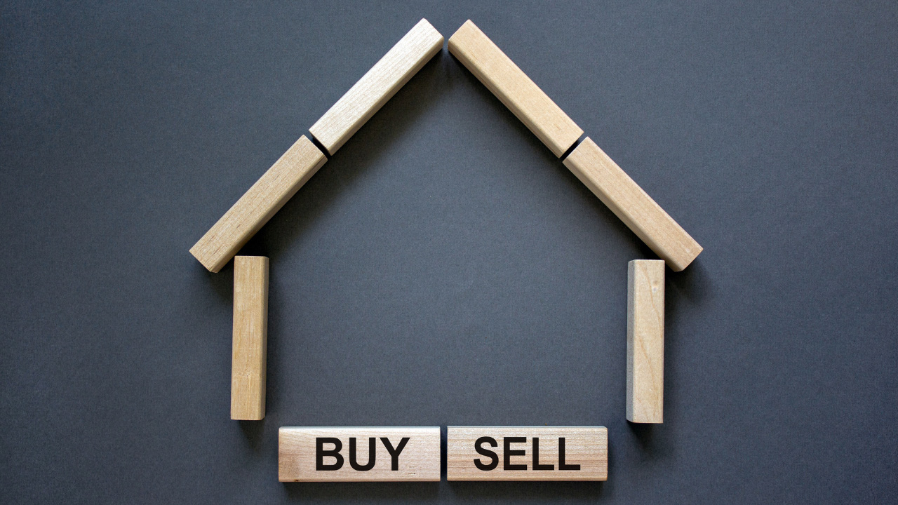 家の形をした木製ブロックと「BUY」「SELL」の文字が並んだ画像