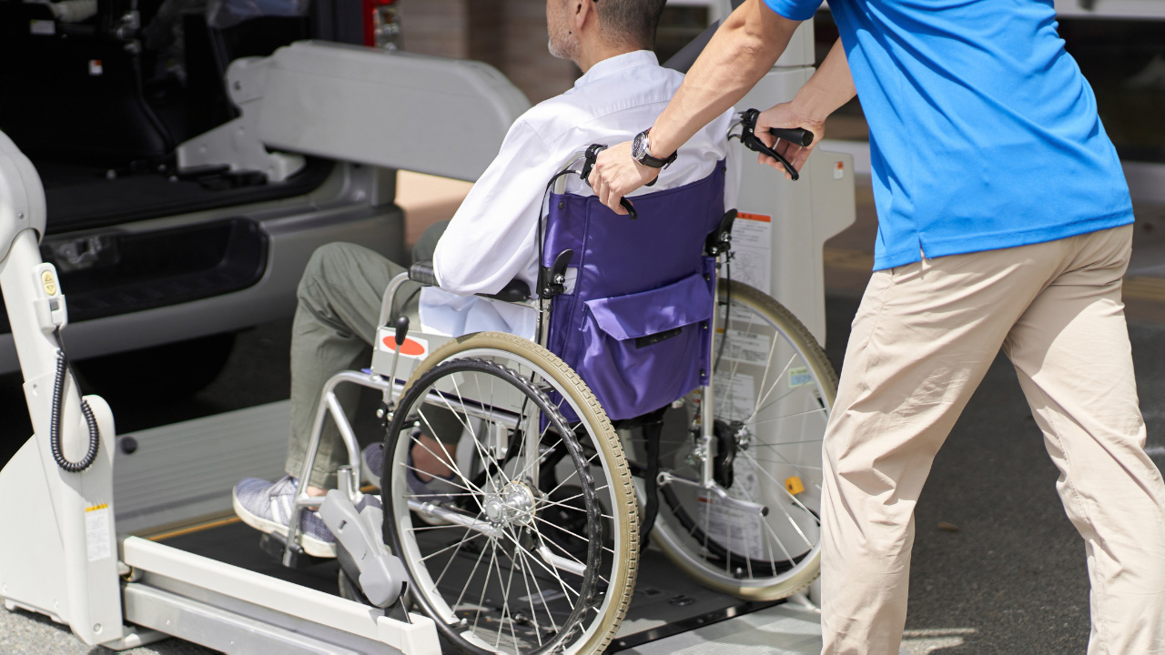 車椅子の男性が介護車両に乗り込む画像