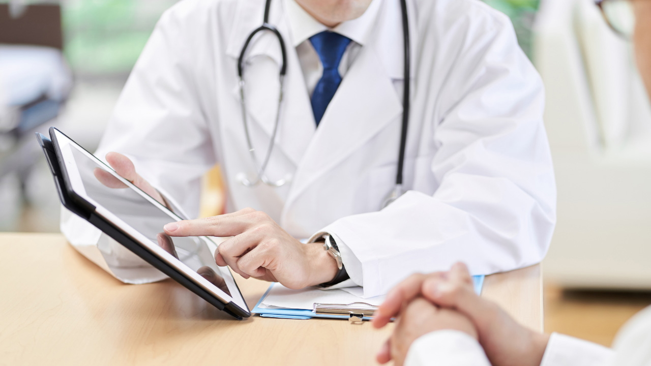 医師がタブレットを使いながら患者に説明している画像