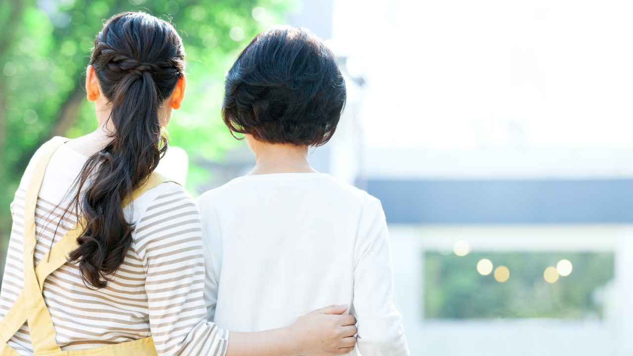 屋外で女性2人が寄り添っている画像