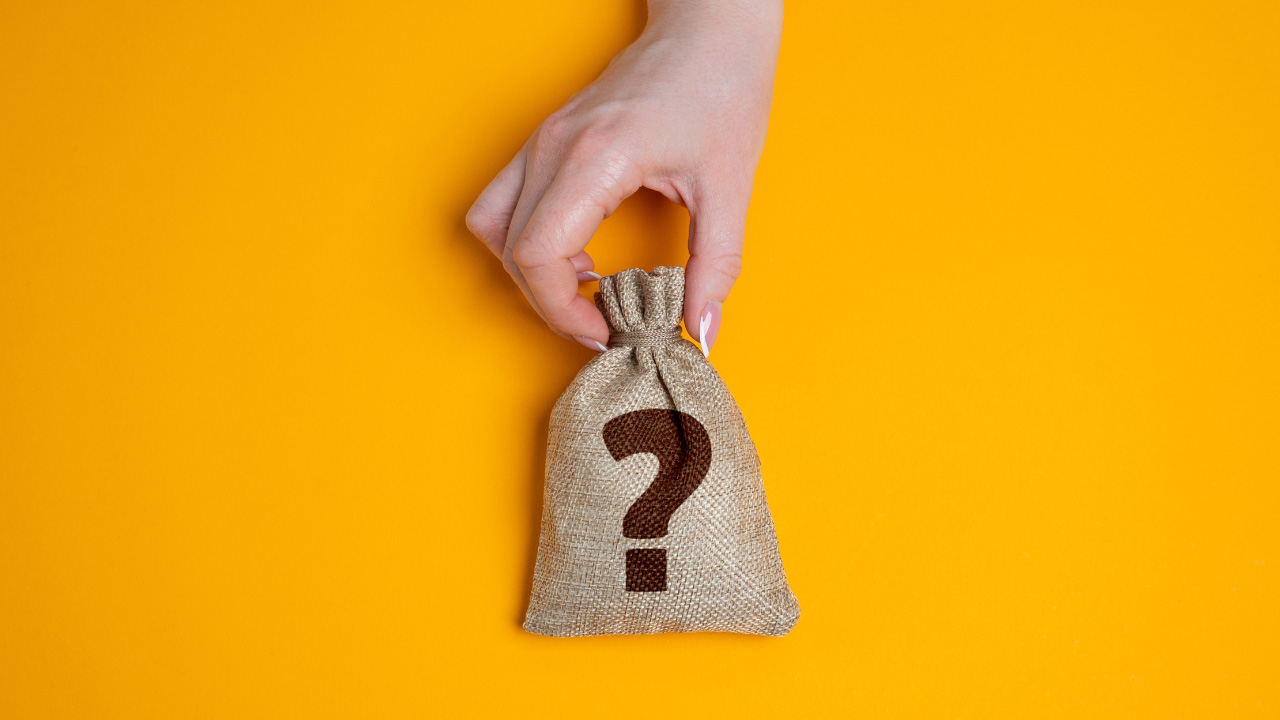 疑問符が描かれている袋を持っている画像