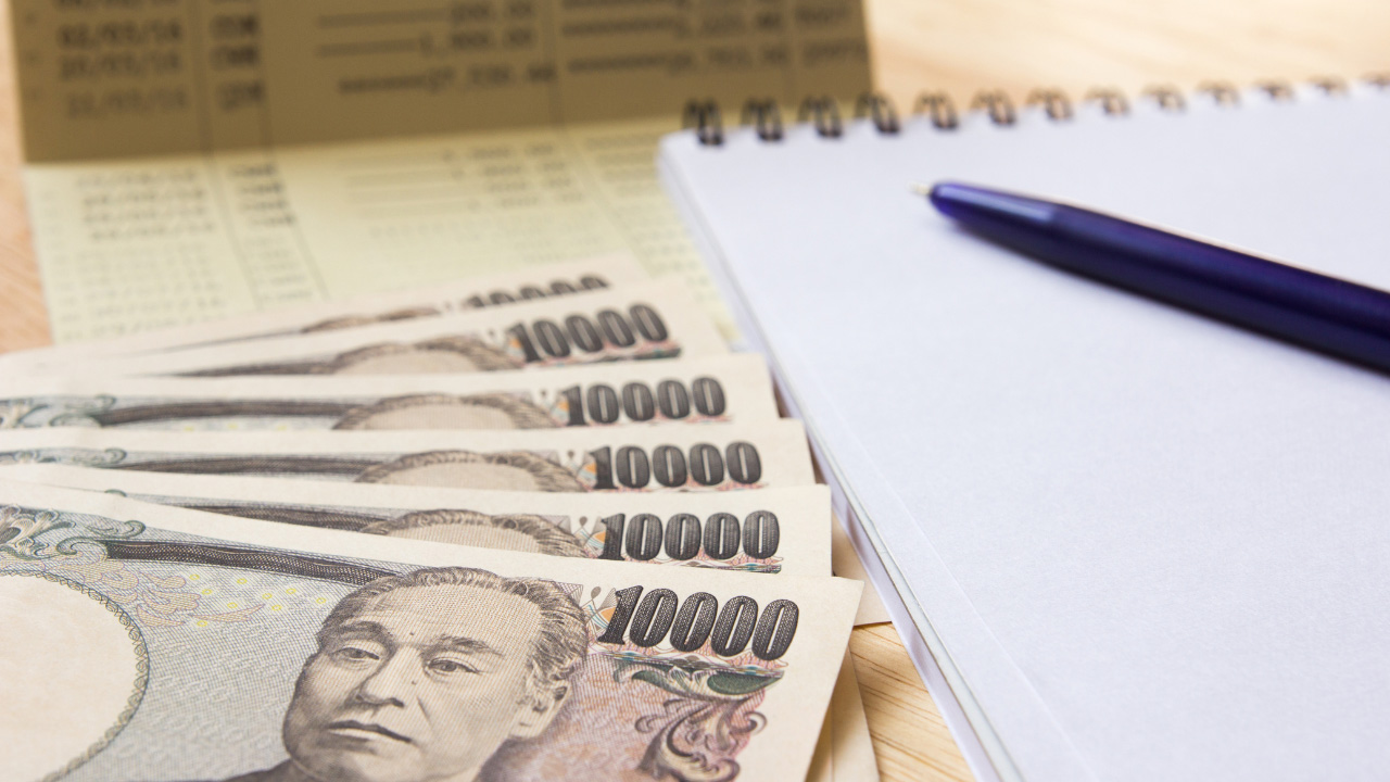 紙幣、通帳、ノート、ペンが並べられた画像