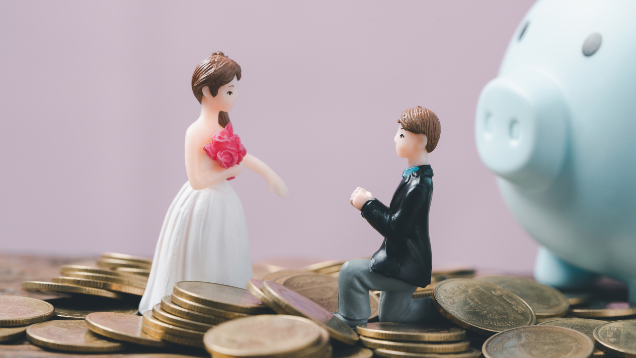 硬貨の上に結婚式の衣装を着たフィギュア、貯金箱の画像