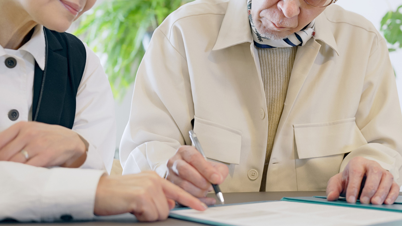 書類にサインをする人の画像